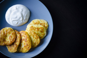Pancakes with zucchini vegetable and sour cream.