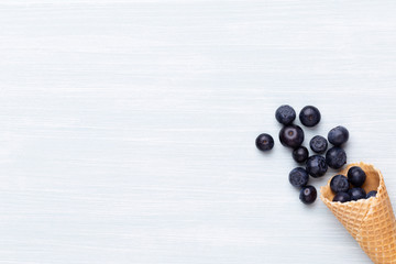 Fresh blueberries, in a heart shaped bowl on a wooden background.