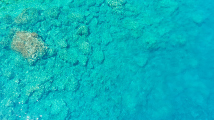 Background image of the turquoise sea. Deep sea and corals. Aerial drone shot of turquoise water.
