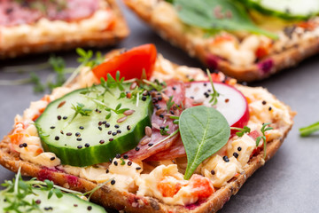 Sandwiches with cream cheese, vegetables and salami.