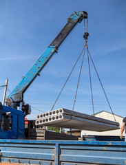 Fototapeta na wymiar A crane raised a concrete slab at a construction site at home