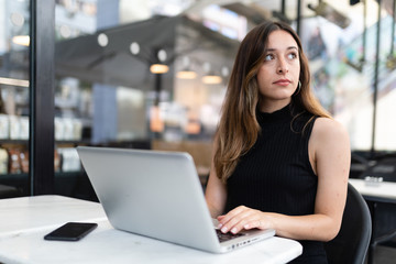 Business woman work process concept. Young woman working university project with generic design laptop. Blurred background, film effect..