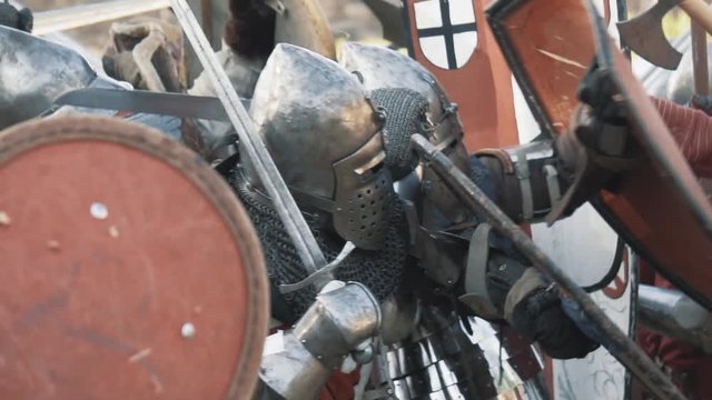 Medieval knight battle. Warriors in full plate armor with melee weapons. Armed men fighting. Real historical warfare reenactment