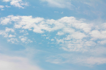 white fluffy clouds slowly float across the blue sky on a blue background