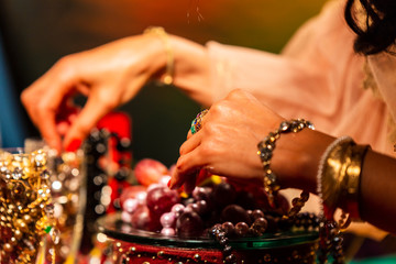 Cropped Hand holding Champagne Flut with Jewellery and Grapes
