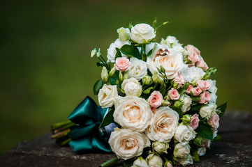 Gold wedding rings on the pink bouquet of flowers