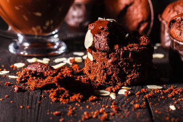 Chocolate muffins with nuts on dark background, selective focus