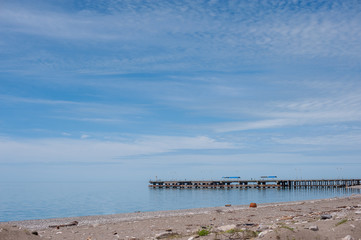 Fototapeta na wymiar Sea pier, blue sky with light clouds