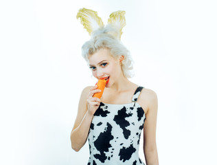 Close-up portrait woman dressing in a bunny costume, eating carrot.