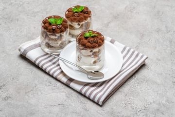 Classic tiramisu dessert in a glass on concrete background