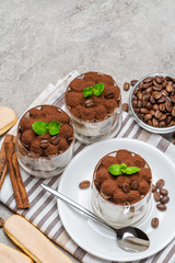 Classic tiramisu dessert in a glass on concrete background