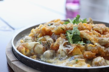 Oyster omelette in hot pan on table
