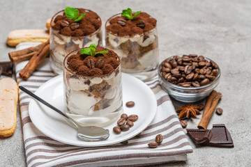 Classic tiramisu dessert in a glass on concrete background