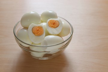 Fototapeta na wymiar boiled eggs in glass bowl on wooden table background
