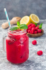 Refreshing raspberry, lemon and mint lemonade with sparkling water in a jar, vertical