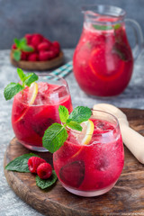Refreshing raspberry, lemon and mint lemonade with sparkling water in  glass, vertical