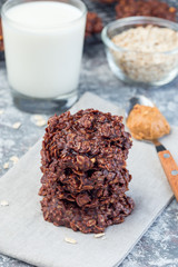 Flourless no bake peanut butter and oatmeal chocolate cookies with glass of milk, vertical