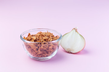Fried onion in the glass, topping for hot dog, fast food, horizontal on pink background