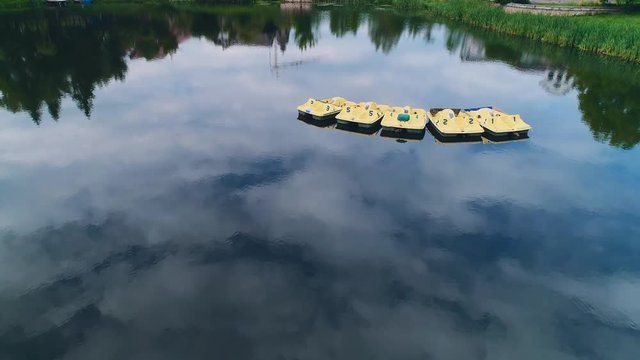 Aerial view of moving slowly paddleboats on the calm lake. 4K.