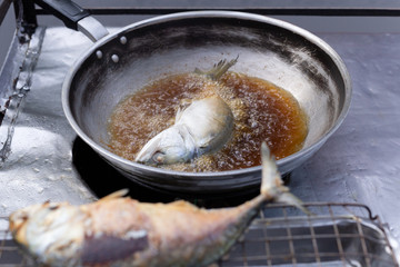 Street vender Deep fried Mackerel fish in hot pan.