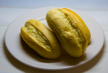 buns of white bread on on white plate with faded background