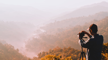 web banner and panorama of earth day and environment care travel concept from photographer man take photo beautiful landscape of tropical forest with haze with soft focus of layer mountain background