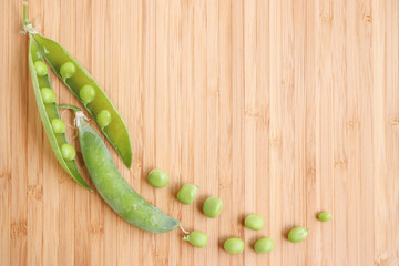 Fresh green peas on a bamboo cutting board background