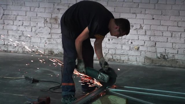 Man works circular saw in slow motion. Flies of spark from hot metal. The man's hard work. Man Chlef and smooth surface. Man worked over the steel. close-up of hand and electric saws metal. Close-up