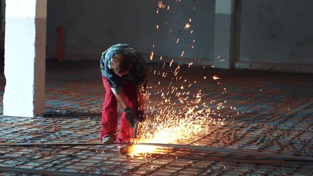 Man works circular saw in slow motion. Flies of spark from hot metal. The man's hard work. Man Chlef and smooth surface. Man worked over the steel. close-up of hand and electric saws metal. Close-up