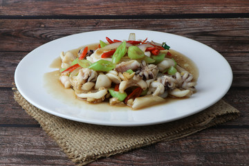 stir-fried squid and basil isolated on wooden background