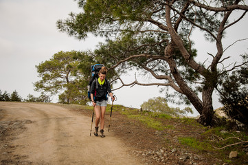 Fototapeta premium Girl walking on the path with hiking backpack