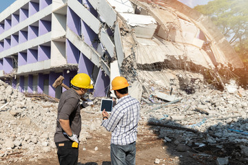 Demolition control supervisor and contractor discussing on demolish building.