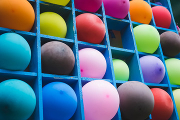 a bunch of colorful balloons on a wooden shelf