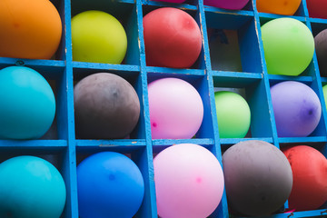 a bunch of colorful balloons on a wooden shelf