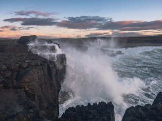 Huge ocean wave hits cliffs creating splash, Dusk time, Concept: storm, cataclysm, West coast of Ireland, Burren region.