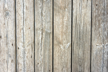 Closeup up view of a wooden fence; spaces between planks are visible. 