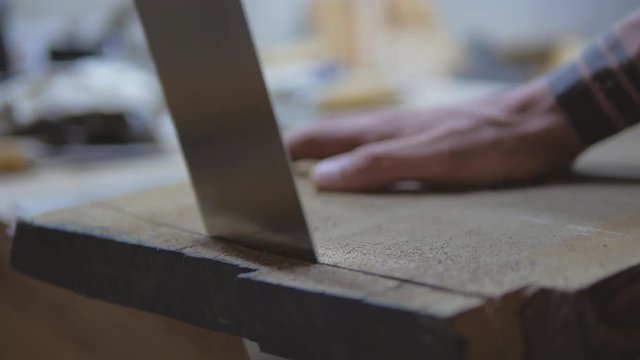 joiner sawing a board with a Japanese saw