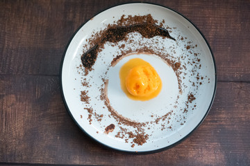 Scoop of passion fruit flavor ice cream with chocolate powder