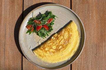 Breakfast. Omelet with tomatoes, arugula, cheese on a blue plate. Frittata - Italian omelette. Top view