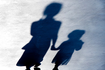 Blurry vintage shadows silhouettes of two person walking  in the night