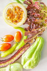 Organic fresh fruits and vegetables flat lay on white paper.