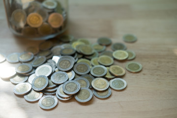 Thai coins in and outside the glass jar, Thai Baht currency