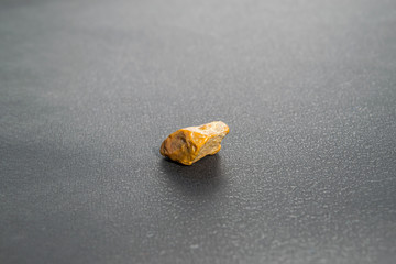 A small piece of amber mineral closeup on a black background