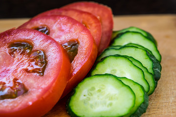 Tomato and cucumber rings closeup on a cutting board, vegetarian food and meal