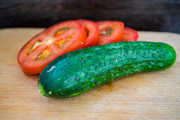 Tomatoes and cucumber on the cutting board for cooking