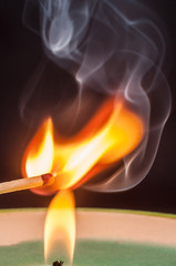 Igniting matches from a candle fire with smoke effectively. Sulfur ignition close up. Macro shooting.