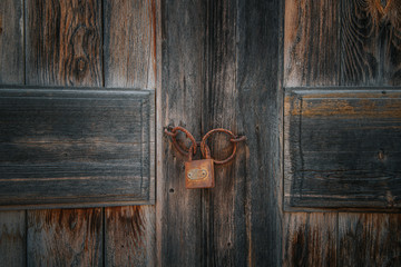 Old rusty lock on the brown vintage wooden door