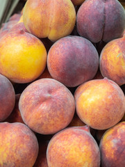several types of  peaches and fruit on the shelf of a fruit store