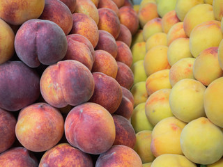 several types of  peaches and fruit on the shelf of a fruit store