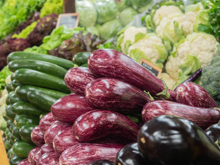 various types of well-ordered vegetables on the shelf of a fruit shop